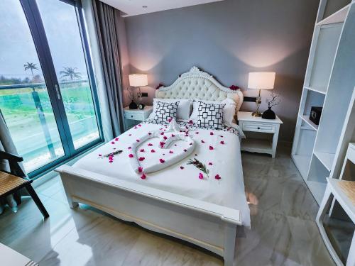 Un dormitorio con una cama blanca con flores. en Sunny Canopy, en Hulhumale