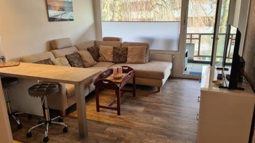 ein Wohnzimmer mit einem Sofa und einem Tisch in der Unterkunft PEMATRA Ferienwohnung Strandmuschel in Travemünde