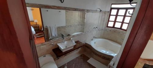 a bathroom with a sink and a bath tub at Hotel Bosque de la Villa in Villa de Leyva
