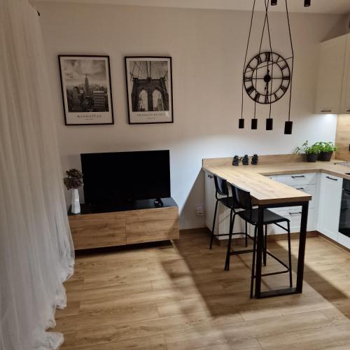 Pniewy的住宿－Apartament Studio，厨房以及带桌子和电视的用餐室。