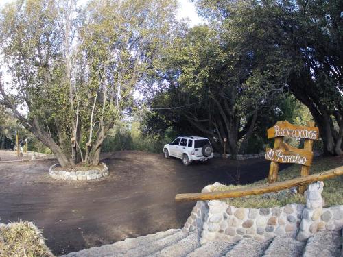 a white truck parked in a parking lot with trees at Hosteria Al Paraiso in Villa Pehuenia