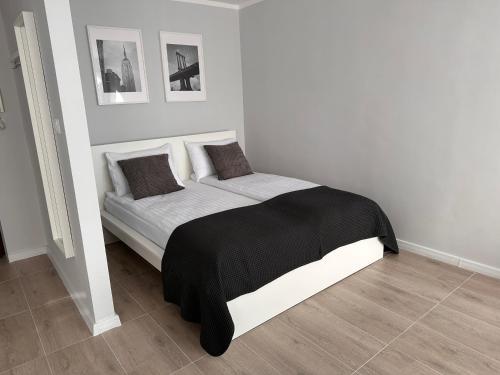 um quarto com uma cama com um cobertor preto e branco em APARTAMENT OŚ. ZŁOTE 5F em Dzierżoniów