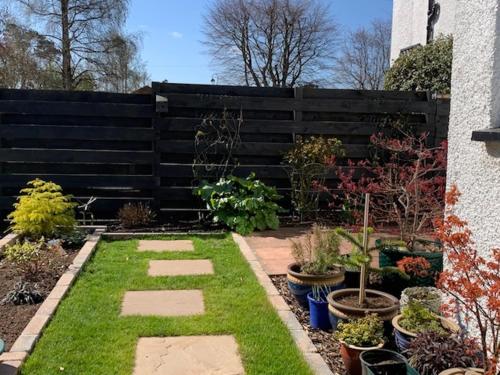 a garden with plants in front of a fence at Pinewood Country House in Leuchars
