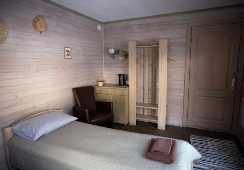 a bedroom with a bed and a chair and a desk at Kempings Ozolkalns in Cēsis