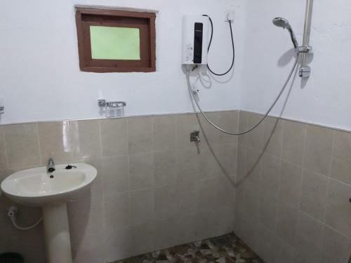ein Bad mit einer Dusche und einem Waschbecken in der Unterkunft Kandy Okaya in Kandy