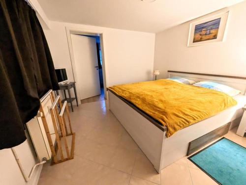 a bedroom with a large bed with a yellow blanket at Ferienwohnung Lena in Schwerin- Wickendorf in Schwerin