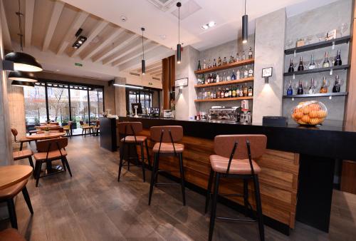 a restaurant with a bar with chairs and tables at Alexandar Square Boutique Hotel in Skopje