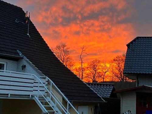 a sunset over the roofs of houses with trees at Ferienwohnung im Grünen mit Balkon in Herdecke