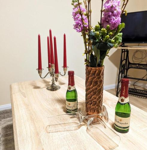 duas garrafas de vinho sentadas numa mesa com velas em Ferienwohnung Lena in Schwerin- Wickendorf em Schwerin