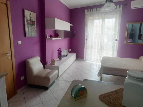 Calangianus的住宿－Monolocale，紫色的客房配有一张床和一把椅子