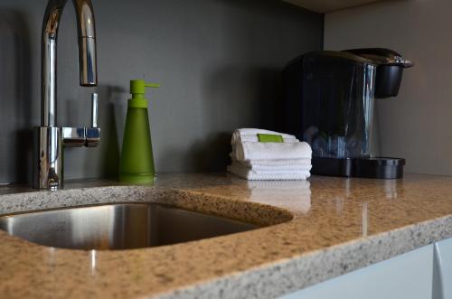 a kitchen counter with a sink and a green blender at First Avenue Executive Suites in Prince Rupert