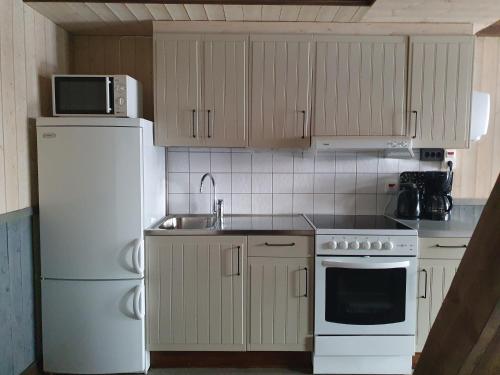 a kitchen with white appliances and a white refrigerator at Epokgården in Öregrund