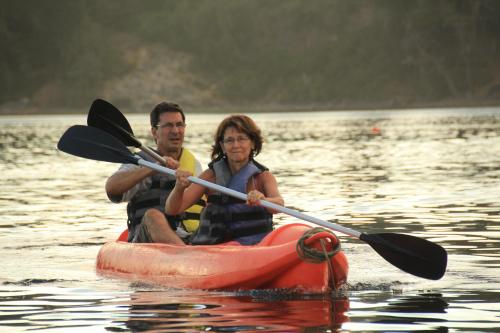 a man and woman in a kayak on the water at Hosteria Al Paraiso in Villa Pehuenia