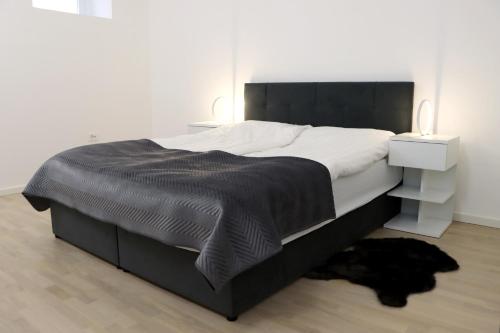 sypialnia z dużym łóżkiem z czarną kołdrą w obiekcie Lumi - modern apartment with parking w Mariborze