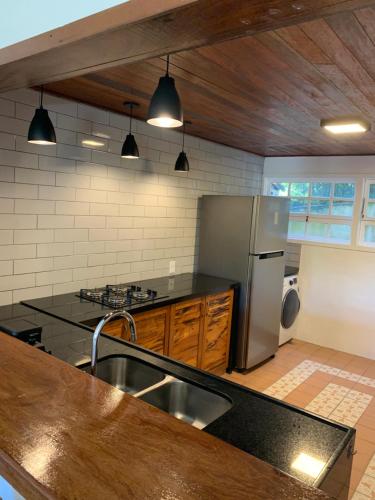 a kitchen with a sink and a refrigerator at Buzios, Amazing Location, Fully Equipped, Great Pool! in Búzios
