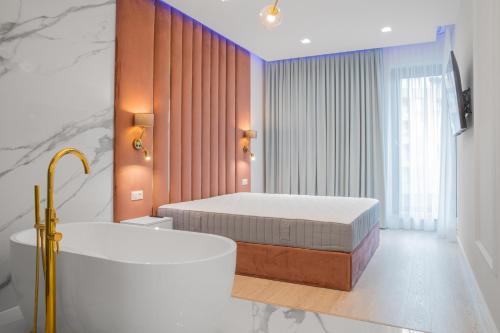 a bathroom with a bed and a bathtub and a bath tub at Apartament Amber Centrum Lux in Gdańsk