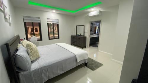 a bedroom with a bed with a green ceiling at The Roseville in Ocho Rios