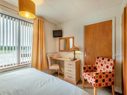 1 dormitorio con cama, escritorio y silla en Barn Owl en Horsford