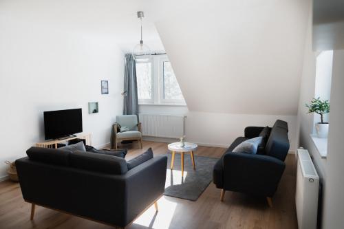 a living room with two couches and a tv at our farm Ferienwohnung in Grasberg