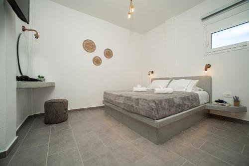 a bedroom with a bed with white walls and a window at Litmus in Fira