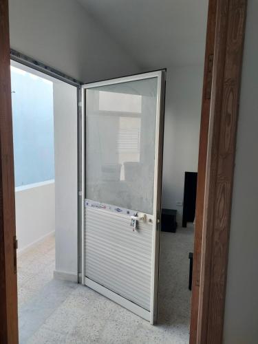 a glass door leading into a room with an empty room at Tiba soliman plage in Nabeul
