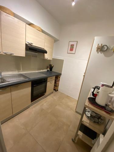 une cuisine avec des armoires en bois et un comptoir dans l'établissement 2 pièces hyper centre, à Nice