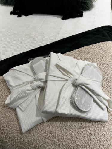 a pile of white towels and a pair of shoes at Luxe City Hot Tub: Urban Retreat in Norwich
