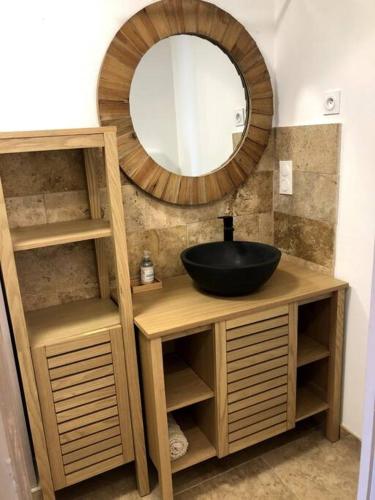 une salle de bain avec un lavabo et un miroir dans l'établissement Appartement au milieu des oliviers, à Rasteau