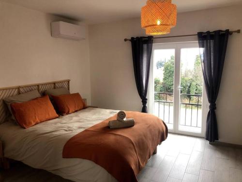 une chambre avec un lit et une grande fenêtre dans l'établissement Appartement au milieu des oliviers, à Rasteau