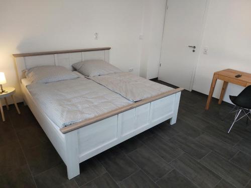 a white bed in a room with a table at Apartments im Mardefeldpalais in Ansbach