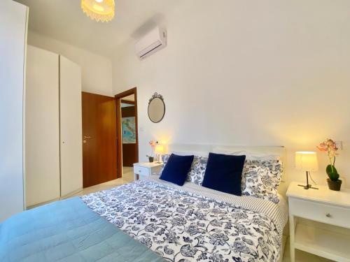 a bedroom with a large bed with blue pillows at TERMINAL Apartment in Genova