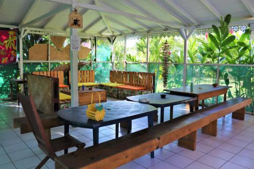 a restaurant with two tables and a bench at Auberge K-WAN Hostel in Deshaies