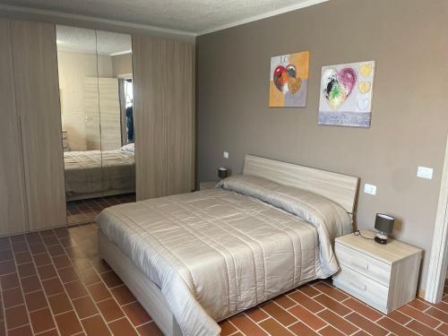 een slaapkamer met een bed en een spiegel bij Maison Younesco - Villa indipendente exclusive in Castagnole Lanze