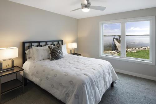 een slaapkamer met een bed en een groot raam bij Lakefront Luxury in Mound