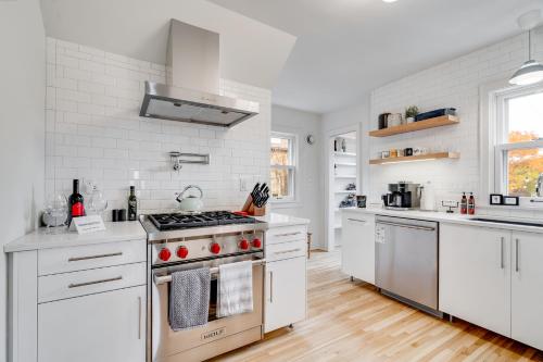 uma cozinha com armários brancos e um forno com placa de fogão em Nokomis Blue em Minneapolis