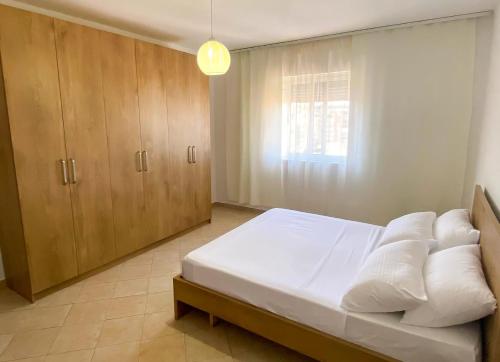 - une chambre avec un lit et des placards en bois dans l'établissement Aldo Apartment, à Tirana