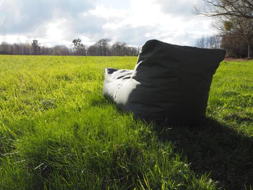 a sleeping bag laying in the grass in a field at Beniaskie! Lake Lodge in West Masuria in Miłakowo