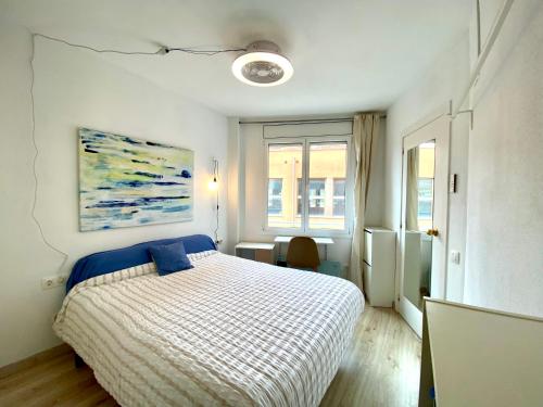 een slaapkamer met een bed en een schilderij aan de muur bij Piscina en Centro de Terrassa in Terrassa