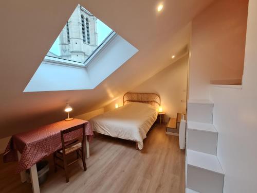 a attic bedroom with a bed and a table at Le Saint Christophe - Mairie d'Aubervilliers ligne 12 in Aubervilliers