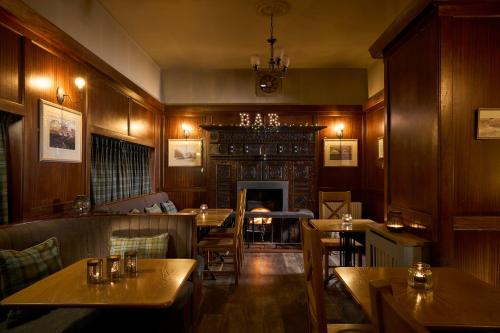 a restaurant with tables and chairs and a fireplace at Ulbster Arms Hotel near Thurso in Halkirk