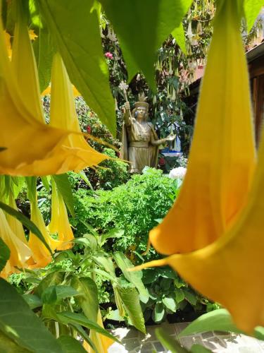 a statue in a garden with green plants at Las Portadas in Ollantaytambo