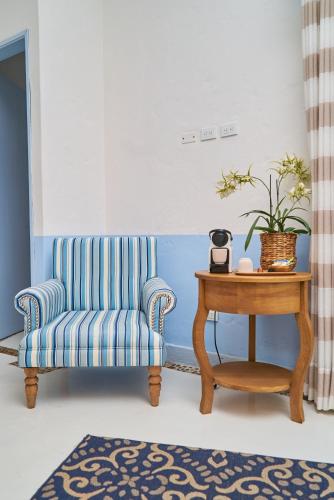 a living room with a blue chair and a table at El Bosque Hotel Boutique in Doradal