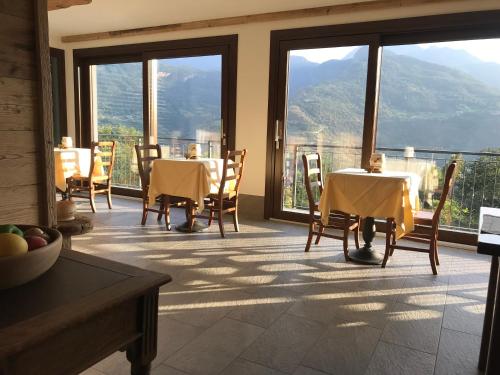 a dining room with tables and chairs with a view at Affittacamere Verger Plein Soleil in Saint-Pierre