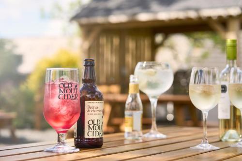 a group of wine glasses and bottles on a wooden table at Ulbster Arms Hotel near Thurso in Halkirk