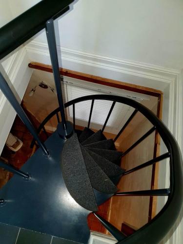 a spiral staircase in a house with a mirror at Rose Tor Hotel in Llandudno