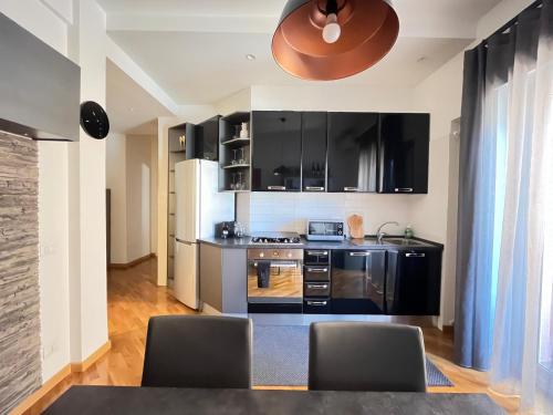 a kitchen with black cabinets and a table and chairs at Davide Rome Apartment in Rome