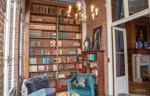 a library with a brick wall filled with books at Hotel Kasteel Hoekelum in Bennekom