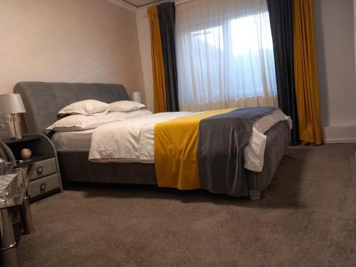 Un dormitorio con una cama grande y una ventana en JACUZZI ROOM, en Târgu Jiu