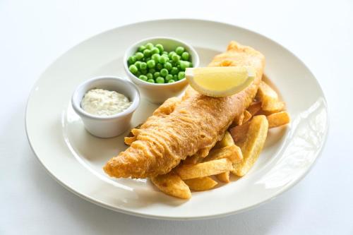 a plate with fish and french fries and a lemon wedge at Ulbster Arms Hotel near Thurso in Halkirk