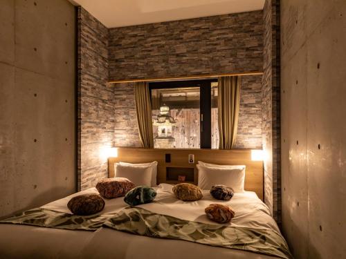 Un dormitorio con una cama con cuatro almohadas encima. en Hale Kyoto Tambaguchi Umekoji Park North, en Kioto